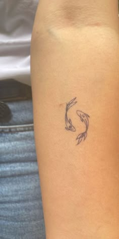 a woman with a tattoo on her arm that has two koi fish in it