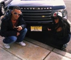 two people sitting next to a black truck