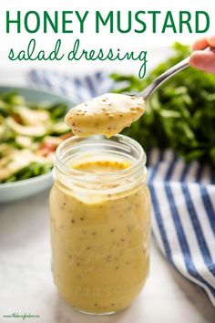 a jar filled with dressing next to a bowl of salad