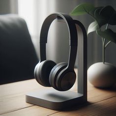 headphones are sitting on top of a wooden table next to a potted plant