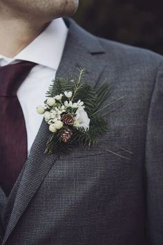 a man in a suit and tie wearing a boutonniere