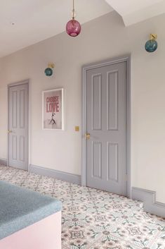 an empty room with two doors and some decorations on the wall above it, in front of a kitchen counter