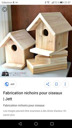 three wooden bird houses sitting on top of each other next to a stack of books