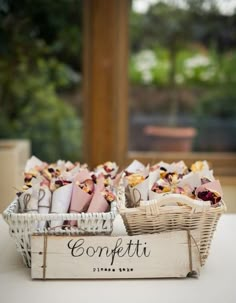 two baskets filled with food sitting on top of a table next to each other and the words confetti written in cursive