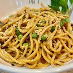 a white bowl filled with pasta and vegetables