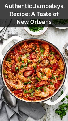 a large pan filled with shrimp and vegetables on top of a white table next to silverware