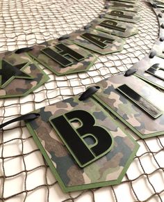 the letters and numbers are made out of camouflage fabric, with black lettering on them