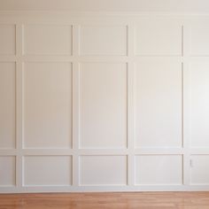 an empty room with white walls and wood flooring on either side of the wall