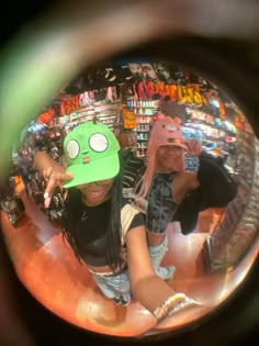 a woman wearing a green hat standing in front of a store filled with merchandise items