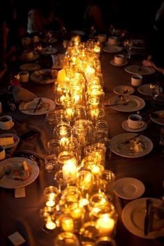 a long table filled with lots of plates and candles