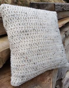 a white pillow sitting on top of a pile of wood