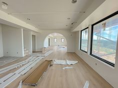 an empty room with wood flooring and windows in the middle is being painted white