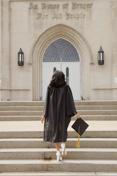 a woman in graduation gown walking up steps