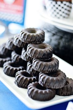 chocolate donuts stacked on top of each other in front of a blue and white plate