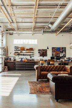 an industrial warehouse with couches and tables in the center, lots of shelves on the wall