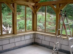 the inside of a house being built with windows and ladders in front of it