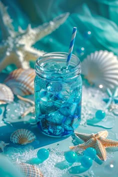 a glass jar filled with blue and white bubbles next to starfish, seashells and shells