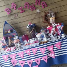 a blue and white table topped with lots of pink items next to a sign that says mama