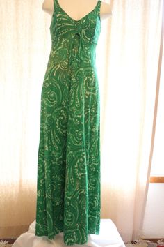 Fun green and white paisley long true vintage dress. The tag says "Olga" Great condition. The 100% nylon Fabric has a little stretch. The bodice is lined and there is a matching tie at the empire waist. Bust measured at under arms 29 inches Empire waist 3 1/2 inches below under arms 27 inches Hips measured 15 inches below under arms 28 inches Length from top of strap to bottom of him 54 inches Green Lined Fitted Maxi Dress, Fitted Green Maxi Dress With Empire Waist, Green Casual Paisley Print Maxi Dress, Casual Green Paisley Print Maxi Dress, Fitted Green Dress With Empire Waist, Casual Fitted Maxi Dress With Paisley Print, Spokane Wa, Nylon Fabric, Vintage Dress