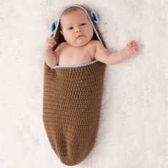 a baby is laying down in a crocheted sleeping bag