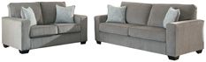 two gray couches with pillows on them sitting side by side in front of each other