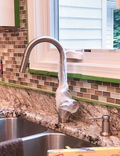 a kitchen sink and counter with a box of clacks next to the faucet