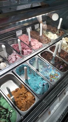 an assortment of ice creams in trays on display