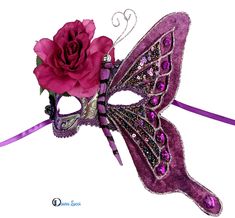 Purple butterfly masquerade mask  Purple and silver resin base decorated with purple glitter and purple and silver trims. A large velour butterfly wing decorated with glitter, holographic sequins, beads and crystals covers one side of the mask. The wing have wire structure and is malleable. A magenta rose completes this piece of wearable art. Great home decor for after the party. When ordering please choose which side of the mask you would like the butterfly to be in. Ribbon ties, hand made in A Cool Masquerade Masks, Butterfly Masquerade Mask, Butterfly Masquerade, Holographic Sequins, Wire Structure, Mask Venetian, Magenta Rose, Masquerade Masks, Purple Decor