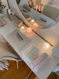 a vanity with candles, towels and other items on it in a room that looks like a bedroom