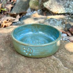 a blue bowl sitting on top of a rock