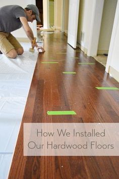 a man that is laying down some kind of floor in the middle of a room