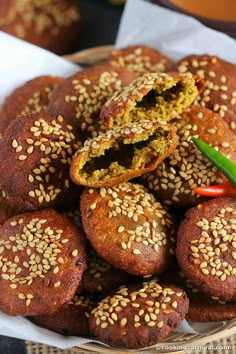 sesame seed rolls in a basket with some dipping sauce