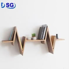 two wooden shelves with books on them against a white wall, one has a plant and the other is a book