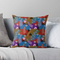 a colorful flower pattern on a brown and blue background throw pillow sitting on top of a couch