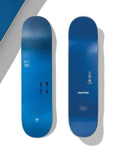 two blue skateboards sitting next to each other on top of a white flooring