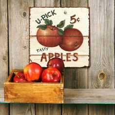 apples are in a wooden box on a shelf next to a sign that reads up pick 5 fast apples