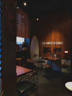 there is a surfboard on the wall in this coffee and radio shop with wooden paneling