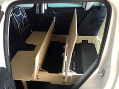 the interior of a car with an open back door and two drawers on each side