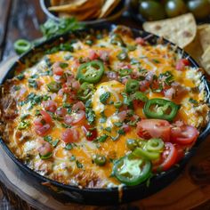 an enchilada with tomatoes, green peppers and cheese in a skillet