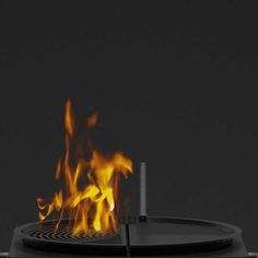 a fire burning in the middle of a black stove top with flames coming out of it