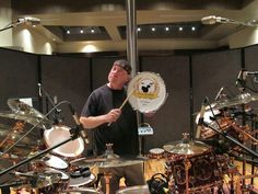 a man playing drums in front of a drum set