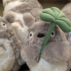 stuffed animals are lined up in a row and one has a green leaf on it