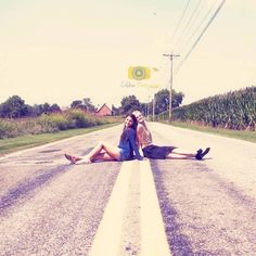 a woman laying on the side of a road with her legs spread out in front of her