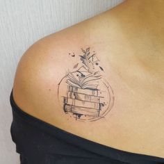 a woman with a book tattoo on her shoulder