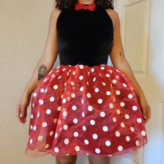 a woman wearing a red and white polka dot skirt with a black shirt underneath her