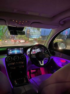 the interior of a car with purple lighting and dashboard lights, including steering wheel controls