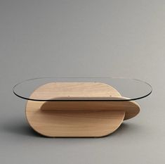 a table with a glass top and wooden base on grey background in front of gray wall