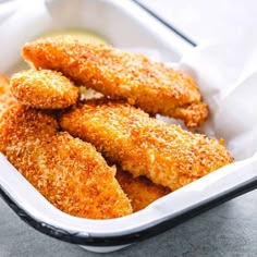 some fried food in a white container on a table