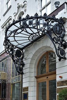 the entrance to a building with ornate iron work on it's front and side