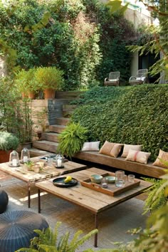 an image of a living room with couches and tables in front of some bushes